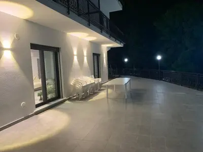 a balcony with a bench on a building at night at Trabia Casa Bianca A in Mandra Capreria