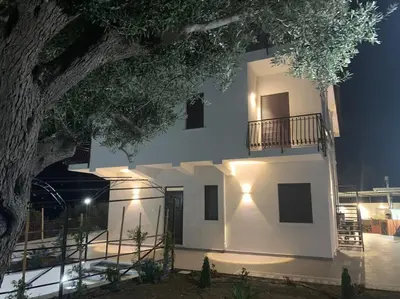 a large white building with a tree in front of it at Trabia Casa Bianca A in Mandra Capreria