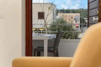 a table with two glasses of wine on a balcony at Casa Vacanze Margherita in San Vito lo Capo