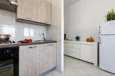 a kitchen with white cabinets and a white refrigerator at Casa Vacanze Margherita in San Vito lo Capo