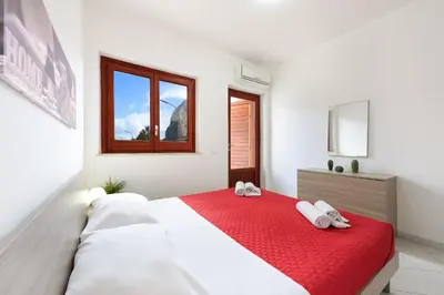 a bedroom with a large bed with red sheets at Casa Vacanze Margherita in San Vito lo Capo
