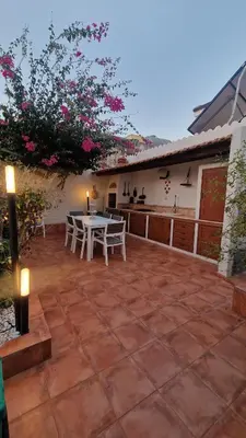 a patio with a table and chairs and a building at Casa Corte Fiorita in San Vito lo Capo