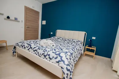 a bedroom with a bed with a blue wall at Porta Nuova Suite & Rooms city center in Palermo