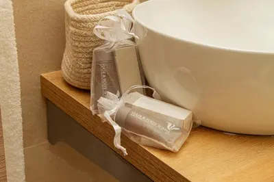 a bathroom shelf with a sink and a bowl and towels at Porta Nuova Suite & Rooms city center in Palermo