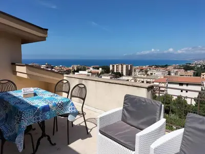 a balcony with a table and chairs and the ocean at Villa Rizzo in Castellammare del Golfo