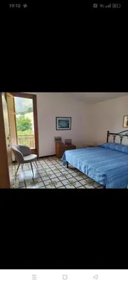 a bedroom with a bed and a chair and a window at Villa Rizzo in Castellammare del Golfo
