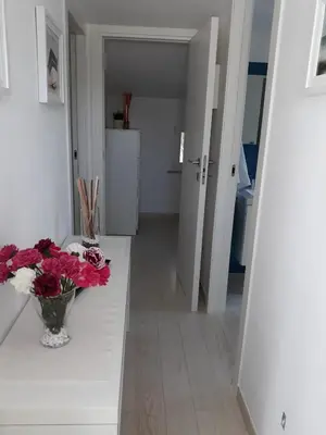 a white hallway with a vase of flowers on a table at Villa Bianca in Alcamo