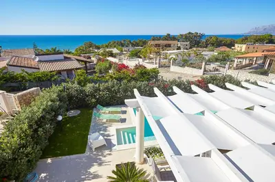 an aerial view of a resort with a swimming pool and the ocean at Villa Bianca in Alcamo