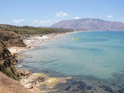 a beach with a bunch of people in the water at Apartment Pirandello by Interhome in Balestrate
