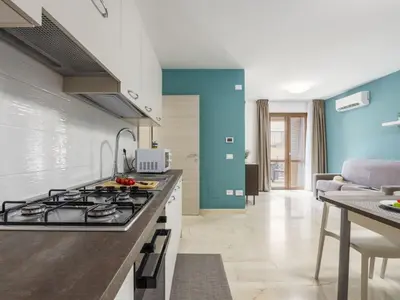 a kitchen with a stove top oven next to a living room at Apartment A Lapa by Interhome in Balestrate