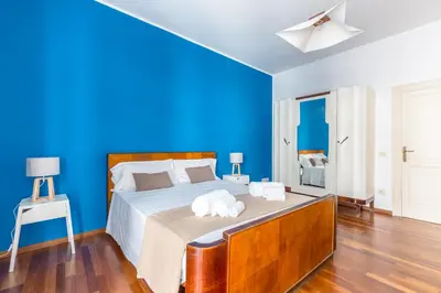 a blue bedroom with a bed with towels on it at Piazza Marina Holiday House by DomuSicily in Palermo