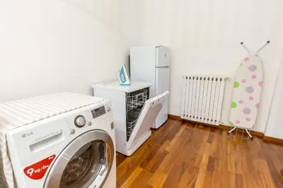 a laundry room with a washing machine and a refrigerator at Piazza Marina Holiday House by DomuSicily in Palermo