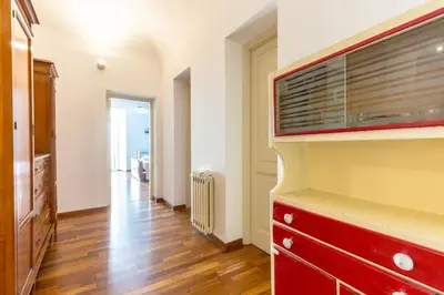 a living room with a red dresser and a tv at Piazza Marina Holiday House by DomuSicily in Palermo
