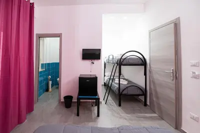 a room with a bunk bed and a chair at Splendori Rooms in Palermo
