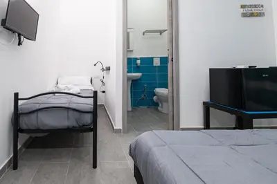 a bedroom with a bed and a bathroom with a toilet at Splendori Rooms in Palermo