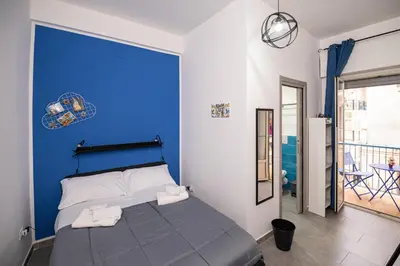 a bedroom with a blue wall and a bed at Splendori Rooms in Palermo