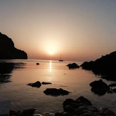 a sunset over a body of water with a sail boat at Casa Praiola in Terrasini