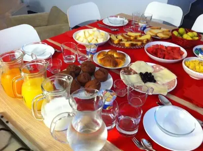 a table with a red table cloth with food and drinks at B&B Giulio Cesare 24 in Palermo