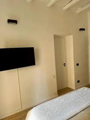 a bedroom with a flat screen tv on the wall at La Dimora Del Centro in Palermo