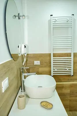 a bathroom with a white sink and a mirror at Sunflower Apartment in Palermo