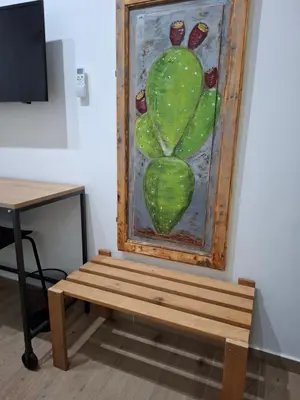 a bench in front of a painting of a cactus at Donna Rosa House in Palermo