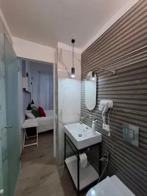 a bathroom with a sink and a mirror and a bed at Donna Rosa House in Palermo