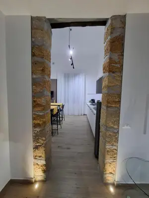a kitchen and dining room with a brick wall at Donna Rosa House in Palermo