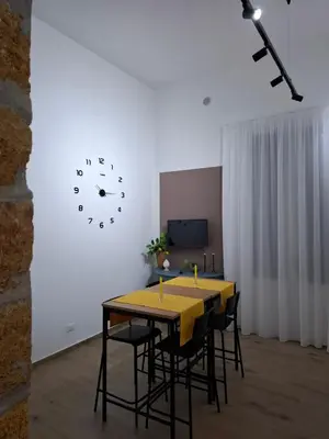 a dining room with a yellow table and chairs and a clock at Donna Rosa House in Palermo