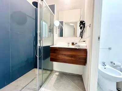a bathroom with a sink and a glass shower at Pretoria Suites in Palermo