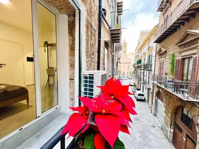 a vase with red flowers sitting on a balcony at Pretoria Suites in Palermo