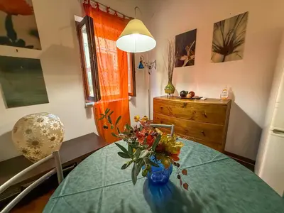 a dining room table with a vase of flowers on it at Loft in Kalsa - By Rental BeB - in Palermo