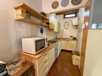 a small kitchen with a microwave and a stove at Loft in Kalsa - By Rental BeB - in Palermo