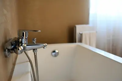 a bathroom with a bath tub with a faucet at Manno's Apartment in Palermo