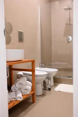 a bathroom with a toilet and a sink and a shower at Manno's Apartment in Palermo