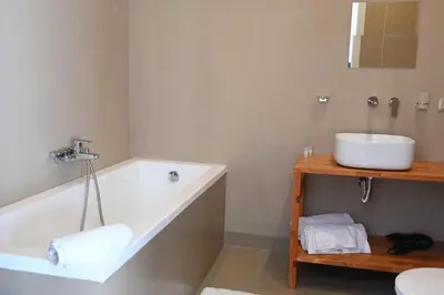 a white bathroom with a tub and a sink at Manno's Apartment in Palermo