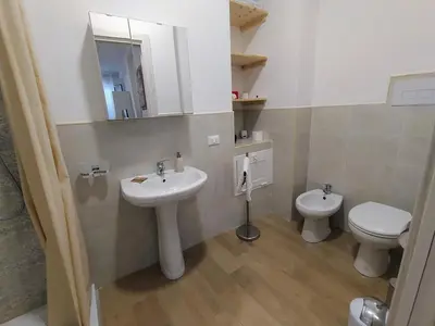 a bathroom with a sink and a toilet and a mirror at Finestra del mare in Isola delle Femmine