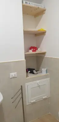 a room with a shelf and a door on a wall at Finestra del mare in Isola delle Femmine
