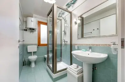 a bathroom with a sink and a toilet and a mirror at Residence Le Perle Beach in San Vito lo Capo
