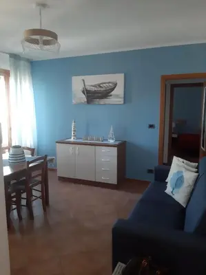 a blue living room with a blue couch and a table at Residence Le Perle Beach in San Vito lo Capo