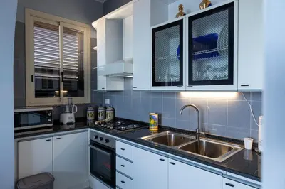 a kitchen with white cabinets and a sink at Trabia Villa Bedda Mia A in Trabia