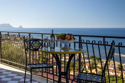 a table with a bowl of fruit on a balcony at Trabia Villa Bedda Mia A in Trabia