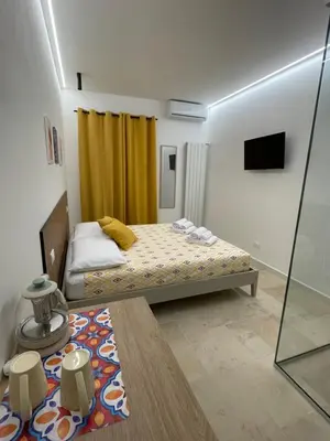 a small bedroom with a bed and a yellow curtain at #Secretplace in Palermo