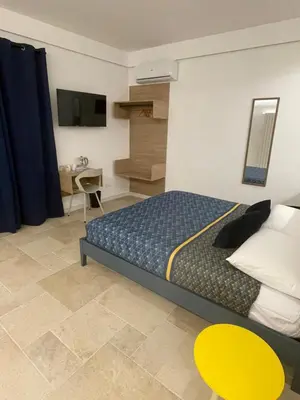 a bedroom with a bed and a desk and a tv at #Secretplace in Palermo