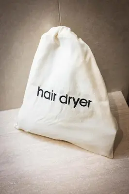 a white bag with the words hair drier on it at Nora's Suites in Palermo