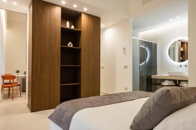 a bedroom with a bed and a bathroom with a sink at Nora's Suites in Palermo