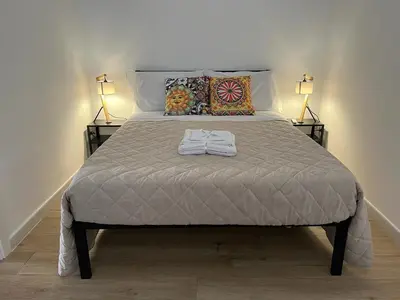a bed with two lamps and a shirt on it at Two-room apartment in the heart of Palermo in Palermo