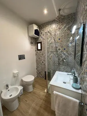 a bathroom with a toilet and a sink and a shower at Two-room apartment in the heart of Palermo in Palermo