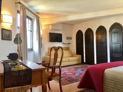 a bedroom with a bed and a couch and a table at Appartamento La Torretta in Mondello