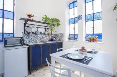 a kitchen with blue cabinets and a table and chairs at Appartamento La Torretta in Mondello