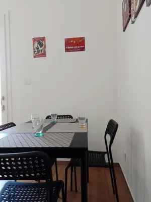 a table with two chairs and a sign on a wall at Holiday home 8 guests Granatelli in Altavilla Milicia